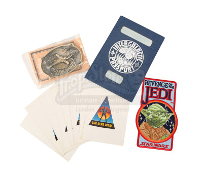 Lot #693 - STAR WARS: ORIGINAL TRILOGY (1977-1983) - Intergalactic Passport Crew Gift, Sealed Brass Belt Buckle, Embroidered Patch and Set of Stickers